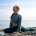 Woman practicing yoga by the sea after asking how long does it take to release trauma from hips.